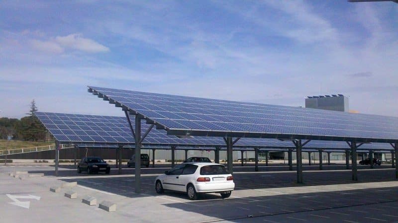 A solar carport structure with panels over the parking bays