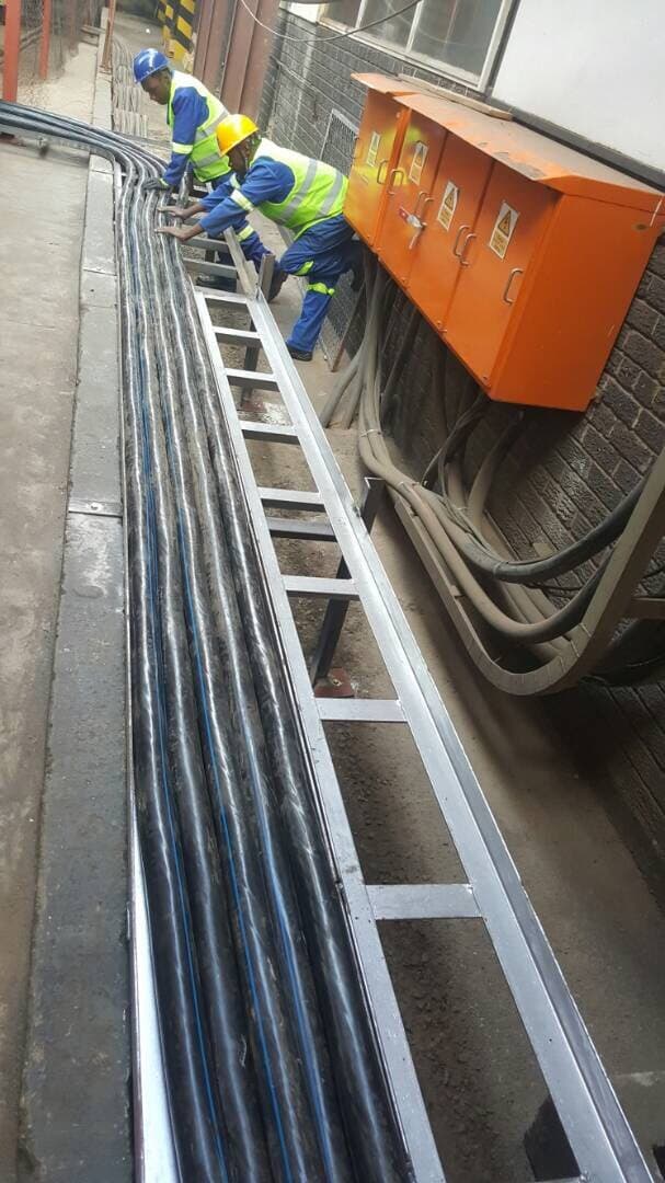 A cable ladder run along a duct wall, with an isolator above it