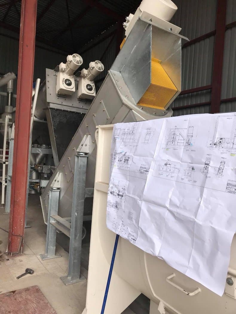 Working drawings pinned up against the plant equipment they describe