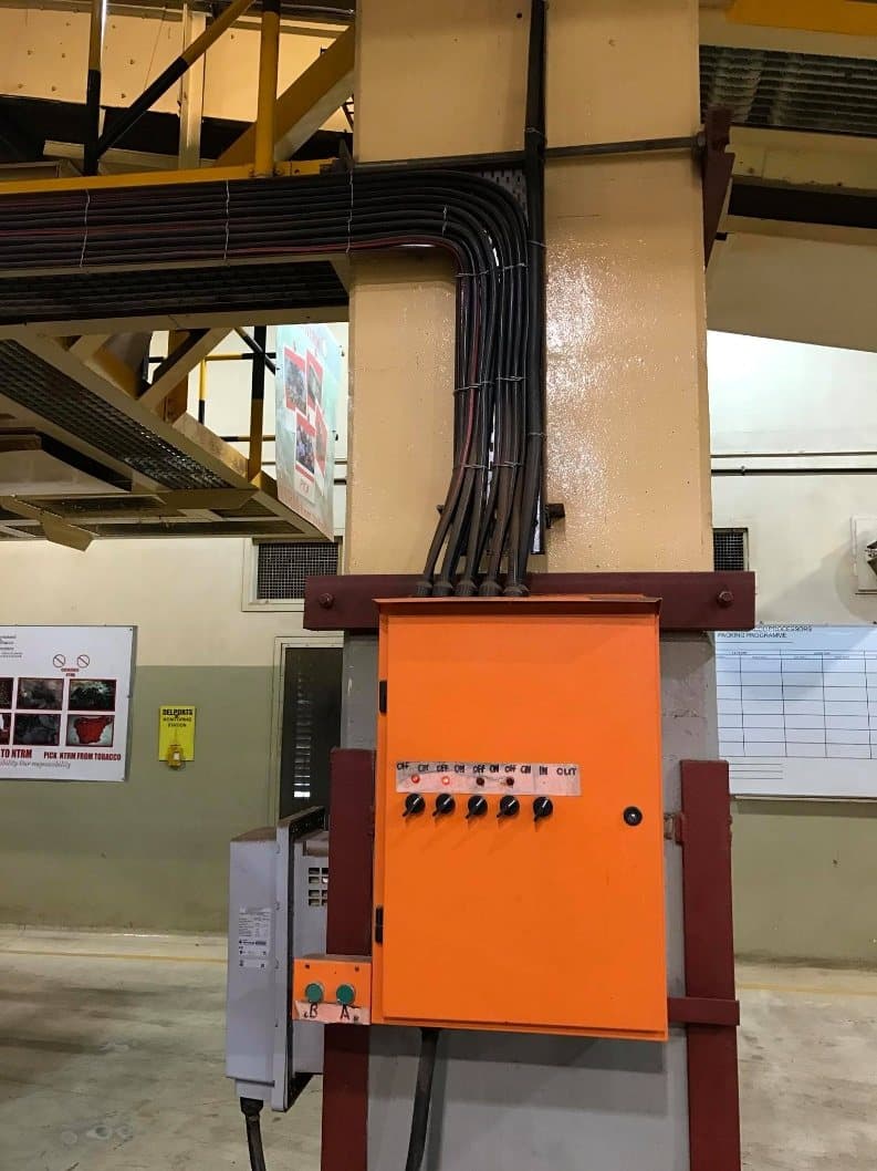 A wall-mounted control panel with its conduit and cabling into the structure above